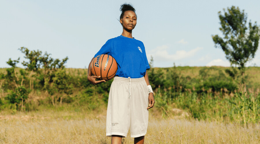 A photograph of an African woman holding a basketball.